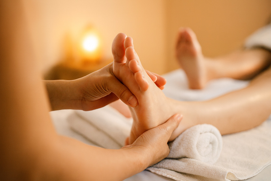 Close-up of a therapist performing a relaxing foot massage during a reflexology session in a spa setting.