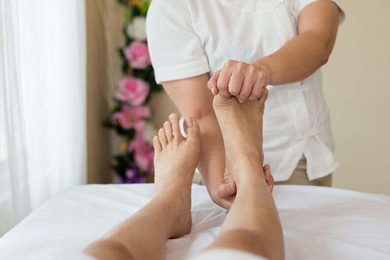 Reflexologist applying pressure to foot points for fibromyalgia relief