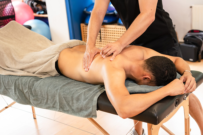 Therapist massaging athlete’s legs to improve muscle recovery