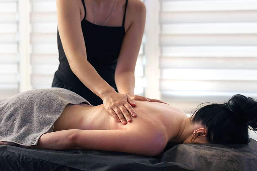 Therapist performing sports massage on athlete’s back muscles
