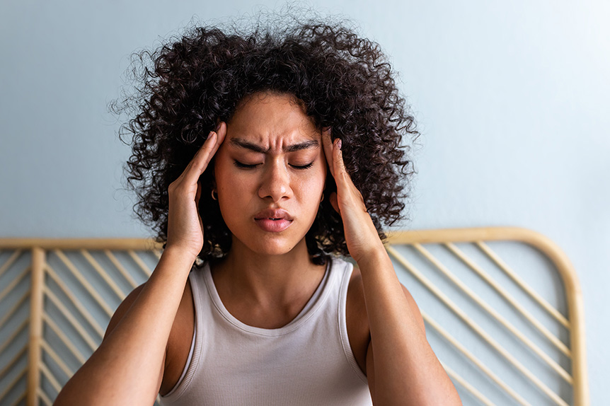 Woman holding her head in pain from migraine