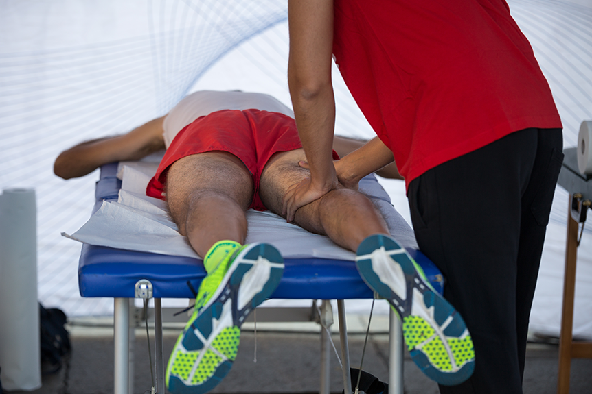Therapist demonstrating proper techniques for giving a sports massage