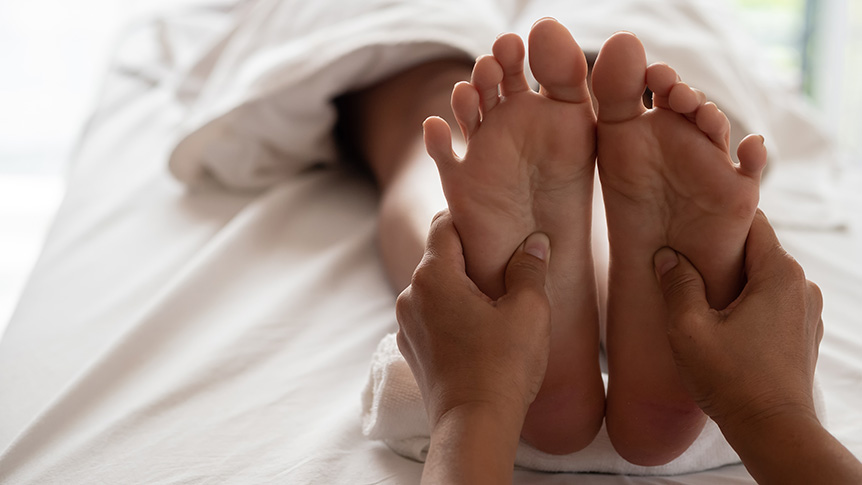 Close-up of a reflexology foot massage aimed at promoting relaxation and helping the body unwind for improved sleep quality.