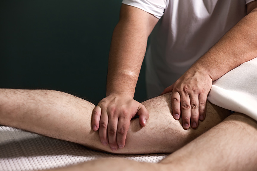 Close-up of a therapist performing a leg massage to support relaxation and wellbeing, not for detecting medical conditions.