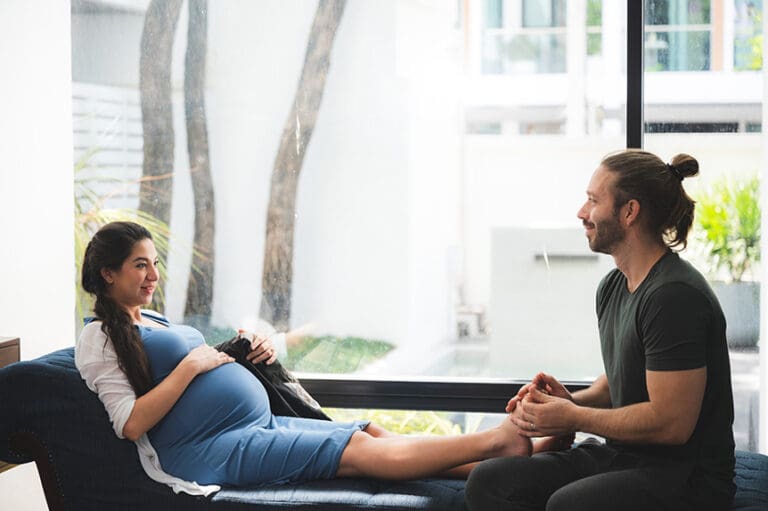 Pregnant woman receiving a gentle foot massage to help reduce swelling and improve comfort during pregnancy.
