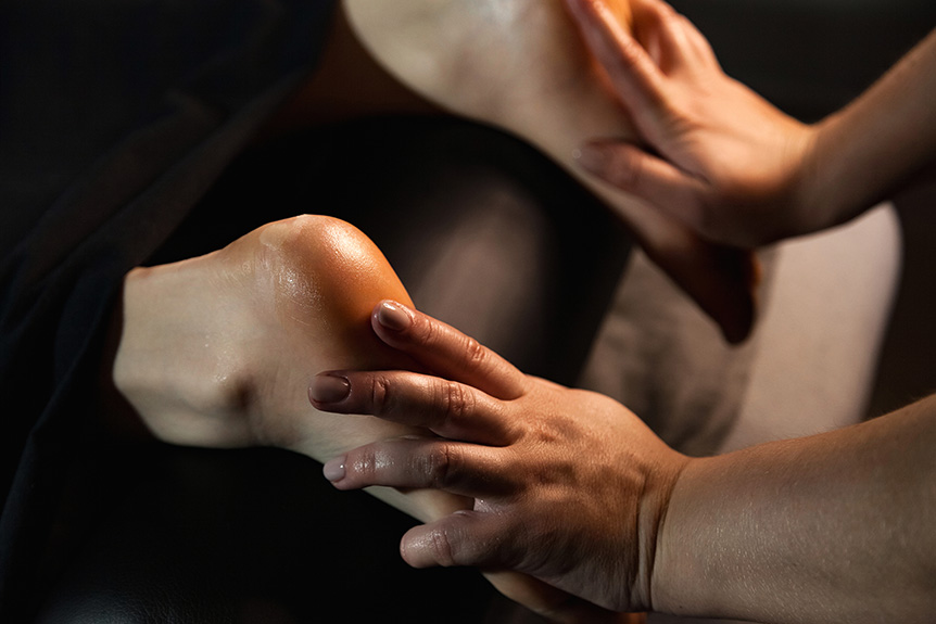 Reflexology practitioner gently massaging a client’s foot using light pressure, a technique that may be adapted for people with diabetes.