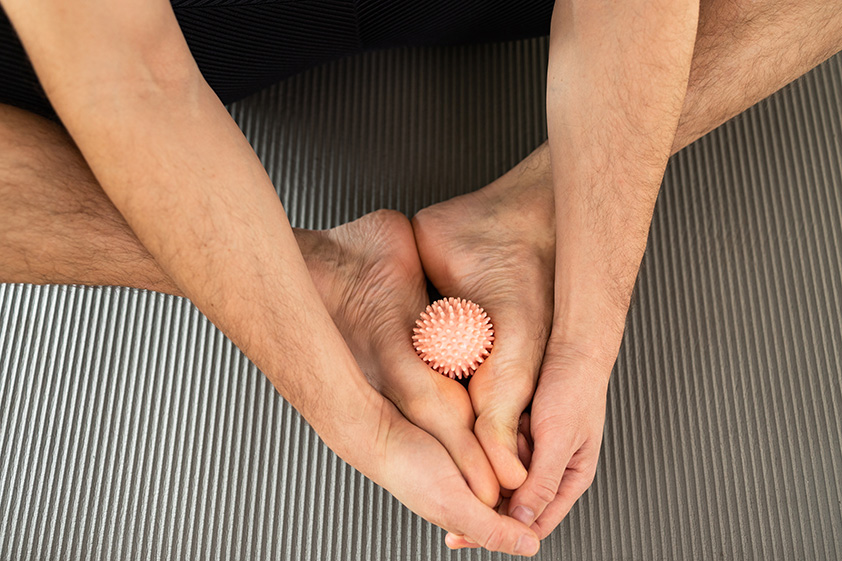 Individual performing self deep tissue massage by pressing and kneading tight muscle areas to relieve tension.