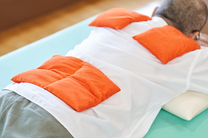 Elderly people who warm their shoulders and hips with a hot pack