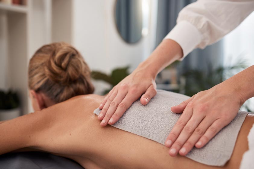 Shot of a mature woman enjoying a hot towel massage at a spa