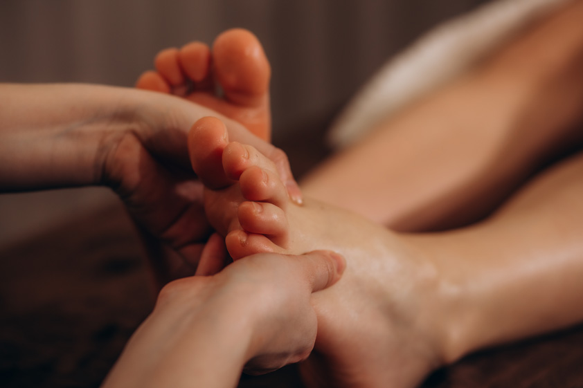 Woman getting relaxing feet massage with oils after long day
