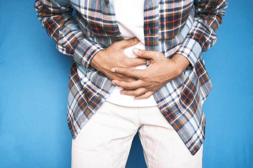 young man suffering stomach pain close up.