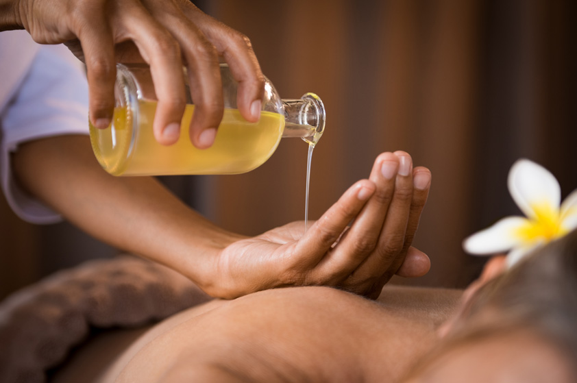 Therapist pouring massage oil