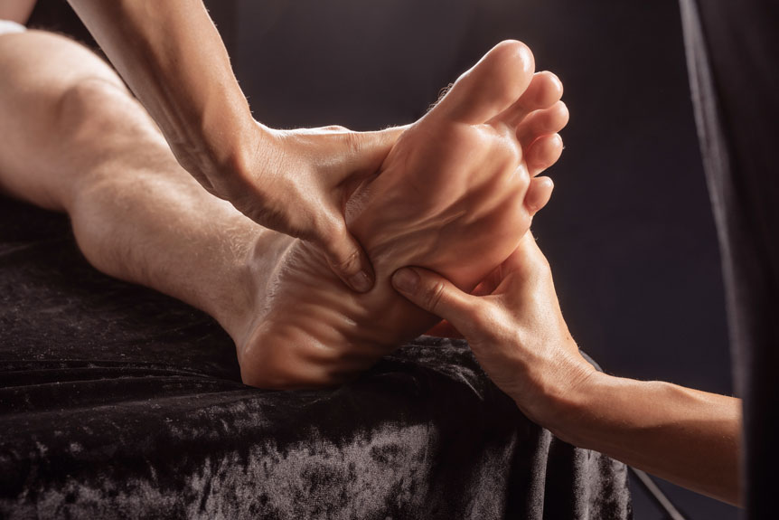 foot receiving massage on soft black material