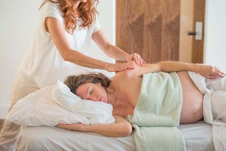 Pregnant woman receiving a professional prenatal massage during a relaxing spa session