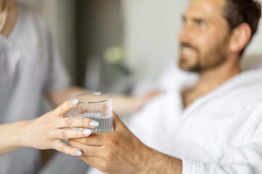 therapist giving drink after massage