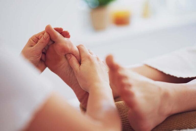 Woman having foot reflexology massage in salon